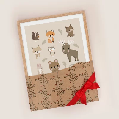 Poster mit Waldtieren im Rahmen, eingepackt in Geschenkpapier mit einer Schleife.