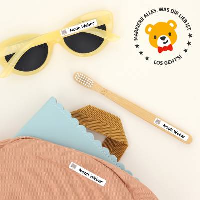Alt-tekst: Personlige navnelapper med navnet 'Noah Weber' festet til solbriller, en bambustannbørste og en fargerik veske. Perfekt for å organisere barnas eiendeler og legge til en personlig touch. Kjøp navnelapper for barn hos vårt nettsted.
