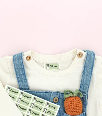 Personalisierte Namensetiketten für Kinderbekleidung mit dem Namen 'Oliver' auf einem bunten T-Shirt und einer blauen Latzhose. Ideal für die Kennzeichnung von Kinderkleidung und zur Vermeidung von Verlust.