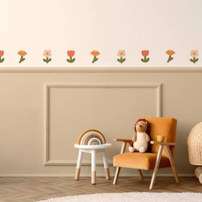 Wanddeko mit Blumenmotiv in sanften Farben über einem gemütlichen Stuhl im Kinderzimmer.