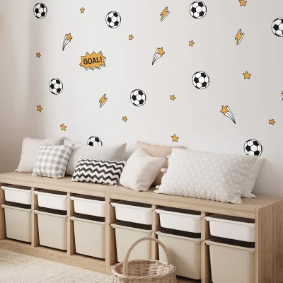 Stylisches Kinderzimmer mit Fußball-Wanddekoration und gemütlicher Sitzecke.