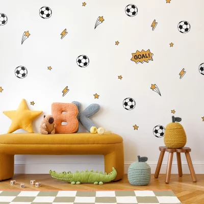 Lebhafte Kinderzimmergestaltung mit fußballförmigen Wandstickern und bunten Kissen auf einer gemütlichen Couch. Die Dekoration schafft eine spielerische Atmosphäre für kleine Fußballfans und peppt den Raum auf.