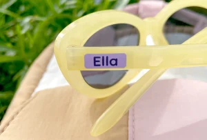Persönliches Namensetikett auf gelben Sonnenbrillen, ideal für Kinder. Die Aufkleber sind perfekt für die Individualisierung von Accessoires und Spielzeug. Entdecken Sie passende Namenslabel und weitere Produkte für Kinderzimmerdekoration und Geburtstagskarten.