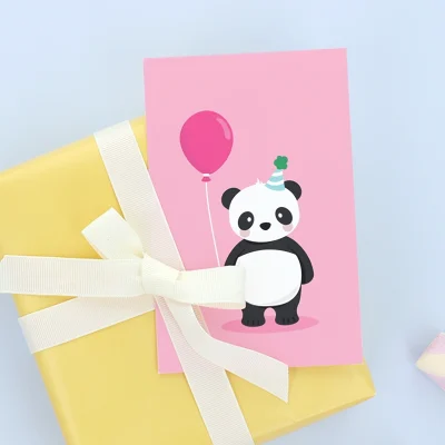 Bunte Geburtstagskarte mit einem fröhlichen Panda, der einen Ballon hält. Die Karte liegt auf einem gelben Geschenk mit einer weißen Schleife und ist ideal für Kindergeburtstage. Perfekt als Ergänzung zu unseren personalisierten Namensetiketten, Kinderzimmer-Dekoren und Plakaten.