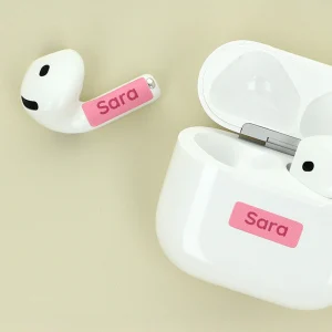 Personalisierte AirPods mit Namensaufkleber in Pink, präsentiert in ihrem Ladecase. Ideal für individuelle Geschenke und stilvolle Aufbewahrung.
