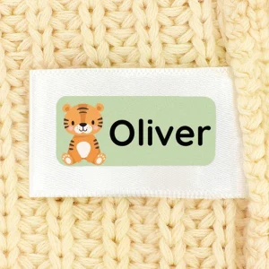 Personalisierte Namensetiketten für Kinder mit einem süßen Tiger und dem Namen „Oliver“ auf einem gestrickten Untergrund. Ideal für persönliche Gegenstände und als dekorative Elemente in Kinderzimmern.